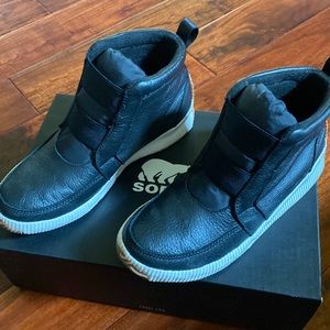 Women’s Sorel Out n About Plus Mid in black leather. Size 9.